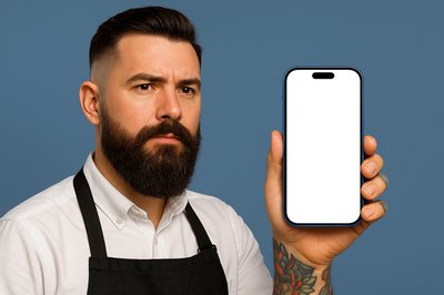 Tattooed Barber Holding a Blue Phone Against a Blue Background